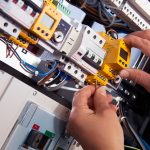 Electricista profesional realizando una reparación en un tablero eléctrico